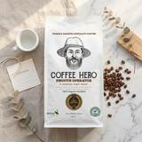 Coffee Hero Smooth Operator bag styled with coffee beans, a white cup, gift note and foliage.